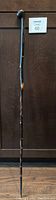 Full view of the 36-inch tall wooden walking stick, showing the stick's length and wear.