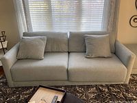 Front view of entire sofa with pillows against window