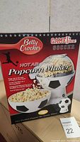 Front view of Betty Crocker GameTime Soccer Hot Air Popcorn Maker box showing popcorn maker with soccer ball design and popped popcorn bowl.