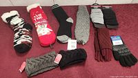 Full lot view showing various ladies leg warmers, gloves, head warmers, and slipper socks arranged on a surface.