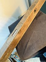 Full view of the antique wooden level showing the bronze fitting with bubble vial on the top surface.