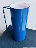 Full view of cobalt blue enameled jug showing cylindrical body and handle