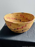 Front angled view of woven basket bowl showing dyed zigzag pattern and natural fiber weaving.