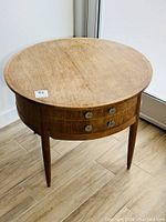 Front elevation view of round teak side table showing overall shape and finish