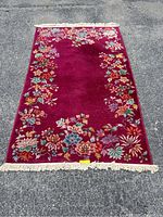Full view of the vintage Chinese Peking Deco rug laid flat outdoors, showing the floral border and fringe.