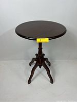 Front view of vintage round wooden end table showing the shape, finish, and legs.