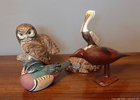 Group photo of 4 bird figurines showing owl, pelican, wood duck and red-brown shorebird