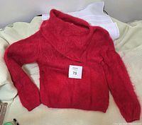 Red thick angora knit sweater with cowl neck laid flat, displaying overall shape and color.
