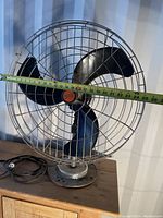 Front view of large vintage Diehl fan showing metal blades and cage with measuring tape indicating blade length of about 27cm.