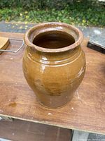 Full side view of the brown antique crock jar showing the bulbous shape and glaze.