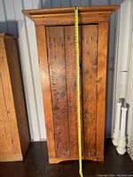 Front view of cupboard with tape measure showing full height