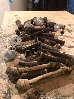 Photo showing an assortment of black iron and galvanized pipe fittings in various sizes laid out on a workbench.