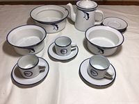 Set of Dansk Flora ceramic coffee cups, saucers, serving bowls, and coffee pitcher arranged on cloth