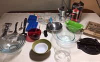 Photo showing array of kitchen items including various glass bowls, utensils, coffee makers, and ice cube trays.