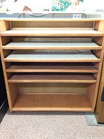 Front view of rolling shelf showing five padded pull-out shelves and open bottom compartment.