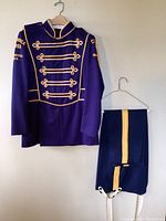 Front view of purple marching band uniform jacket with gold braid and matching navy blue pants with gold stripe