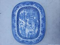 Full view of rectangular Blue Willow transferware platter showing decorative border and imagery.