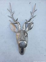 Front view of silver-colored metal deer head wall mount showing detailed face and antlers.