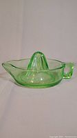 Side view of vintage green glass juicer showing full body and handle