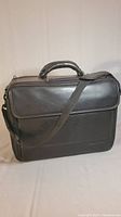 Front view of black Targus leather laptop bag showing reinforced handle and shoulder strap