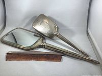 Front view showing the hand mirror, hairbrush, and comb on white background