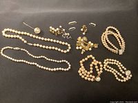 Top-down photo of entire collection showing necklaces, bracelets, earrings and cuffs laid on black surface.