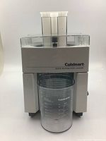 Front view of white and clear plastic Cuisinart juice extractor juicer with juice cup.