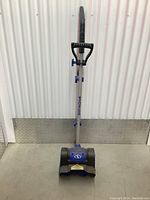 Front view of the small electric snowblower showing entire unit including handle, grip, and base.