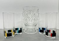 Photo showing four Pierre Cardin drinking glasses with colored geometric patterns around the bottom and a single clear glass vase with embossed circular designs arranged in a line.