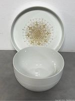 Front view of the bowl showing the white ceramic surface with gold geometric pattern inside.