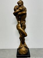 Front view of bronze sculpture of embracing couple on black base