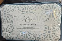 Photo showing Charisma branded packaging with blanket inside, indicating queen size and dimensions 98 x 96 inches.
