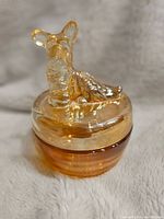 Front view of amber-colored glass trinket dish with Scottie dog lid showing seated dog figurine and dish body