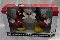 Set of ceramic salt and pepper shakers shaped as Mickey and Minnie Mouse facing each other in original box.