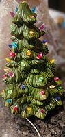 Full view of vintage ceramic Christmas tree with colorful small light bulbs inserted and plugged in.
