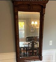 Full front view of the large hand-carved mahogany framed mirror showing detailed carved top and sides.