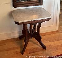 Close-up of white marble top with beveled edge and carved wood apron