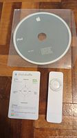 Shows Apple iPod shuffle first generation media player, user manual card, and Apple installation CD.