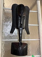 Front view of the handcrafted carved wooden mask wall hanging showing dark stain and stylized features.