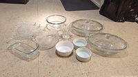 Full set of glassware including plates, bowls, and ramekins with different sizes and shapes, shown on floor.