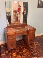 Front view of the mid century modern makeup vanity table with attached mirror and bronze handles on drawers.