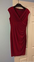 Front and side angle views of deep red sleeveless Ralph Lauren dress hanging on door, showing faux wrap V-neck and side ruching detail.
