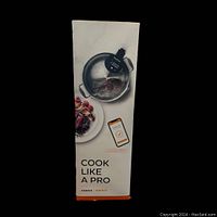 Box side showing sous vide cooker in pot plus prepared dish and smartphone app