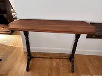 Full view of antique Victorian walnut stretcher table showing top surface and legs.