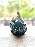 Front view of the Royal Doulton figurine featuring the woman in a blue dress holding a basket.