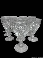 Group of 10 clear crystal aperitif glasses arranged closely showing cut Georgian pattern details on the bowls and the stems.