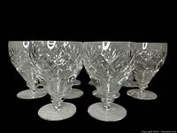Front view of 10 red wine goblets arranged in cluster showing cut crystal patterns and overall shape