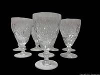 Front view of six Webb Corbett crystal white wine glasses, showing the Georgian cut pattern on the bowls and the short stems with round bases.