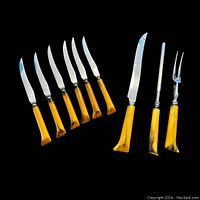 Photo showing 6 steak knives and 3 carving tools with yellow-black patterned handles on a black background