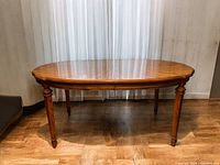 Full view of the oval vintage fruitwood table showing overall shape, leg design and finish.
